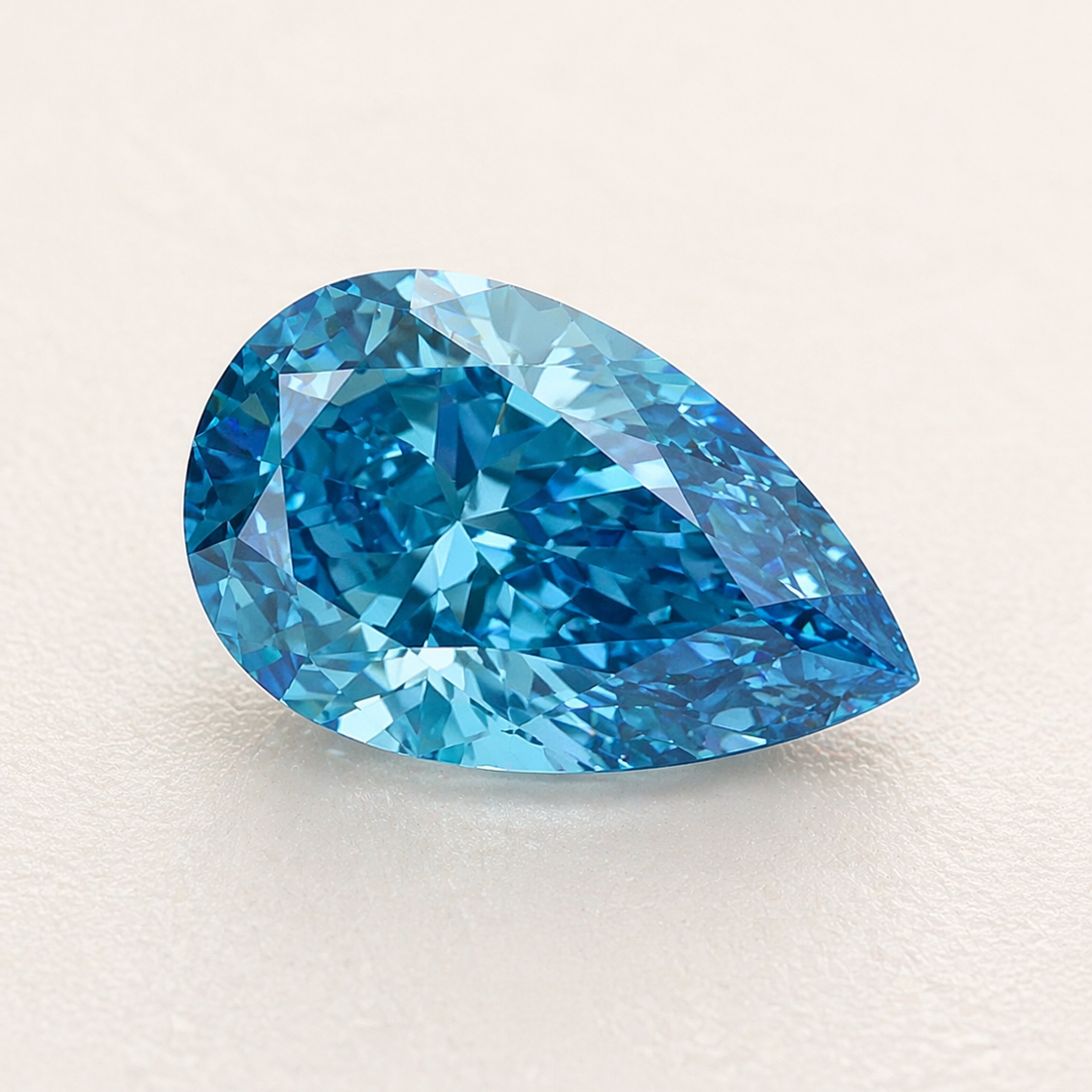 Pear shaped diamond in blue on light ivory background