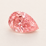 Pink pear-shaped diamond on ivory surface